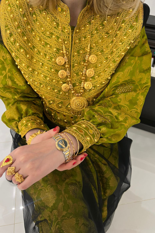 A traditional dress in light clover in olive color with black tulle embroidered with golden threads