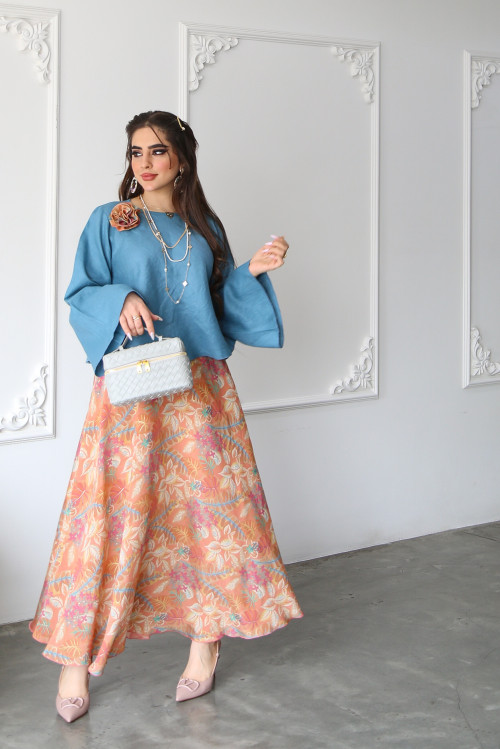 A sky blue linen shirt set with a rose on the shoulder and an apricot printed skirt