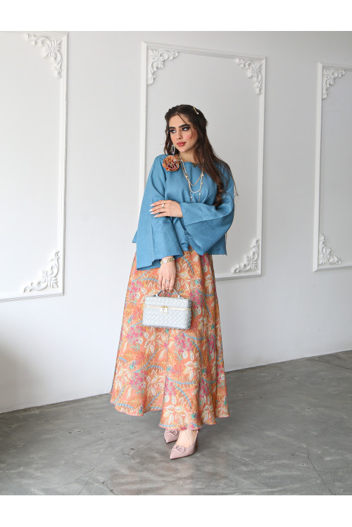 A sky blue linen shirt set with a rose on the shoulder and an apricot printed skirt