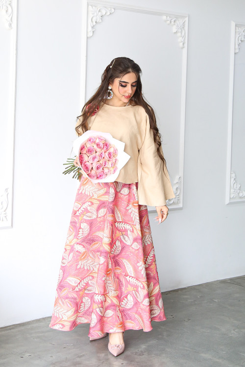 A beige linen shirt set with a rose on the shoulder and a pink printed skirt