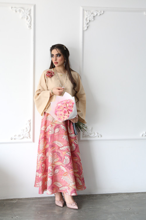 A beige linen shirt set with a rose on the shoulder and a pink printed skirt